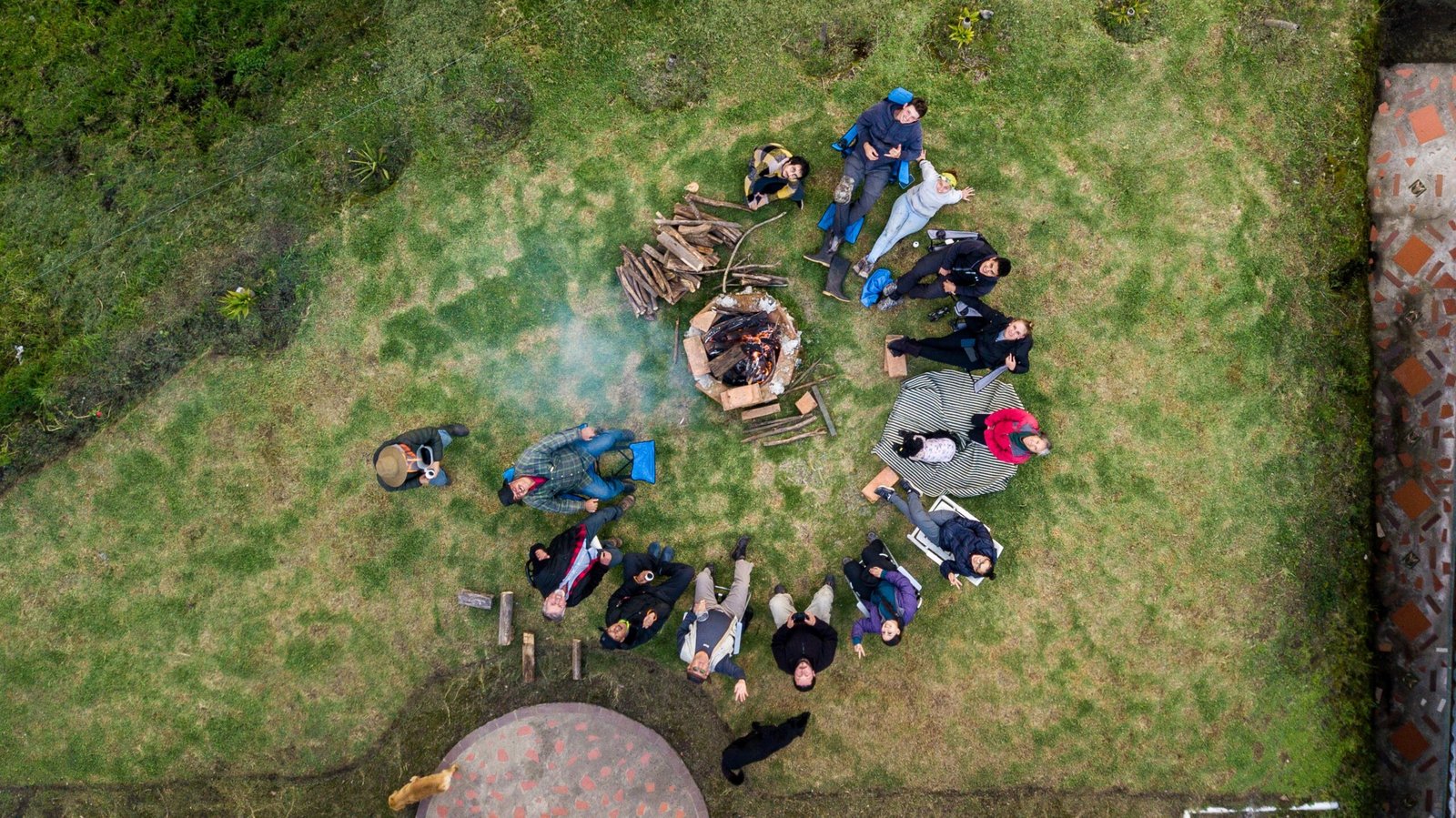Aerial view group people surrounding fire pit campsite